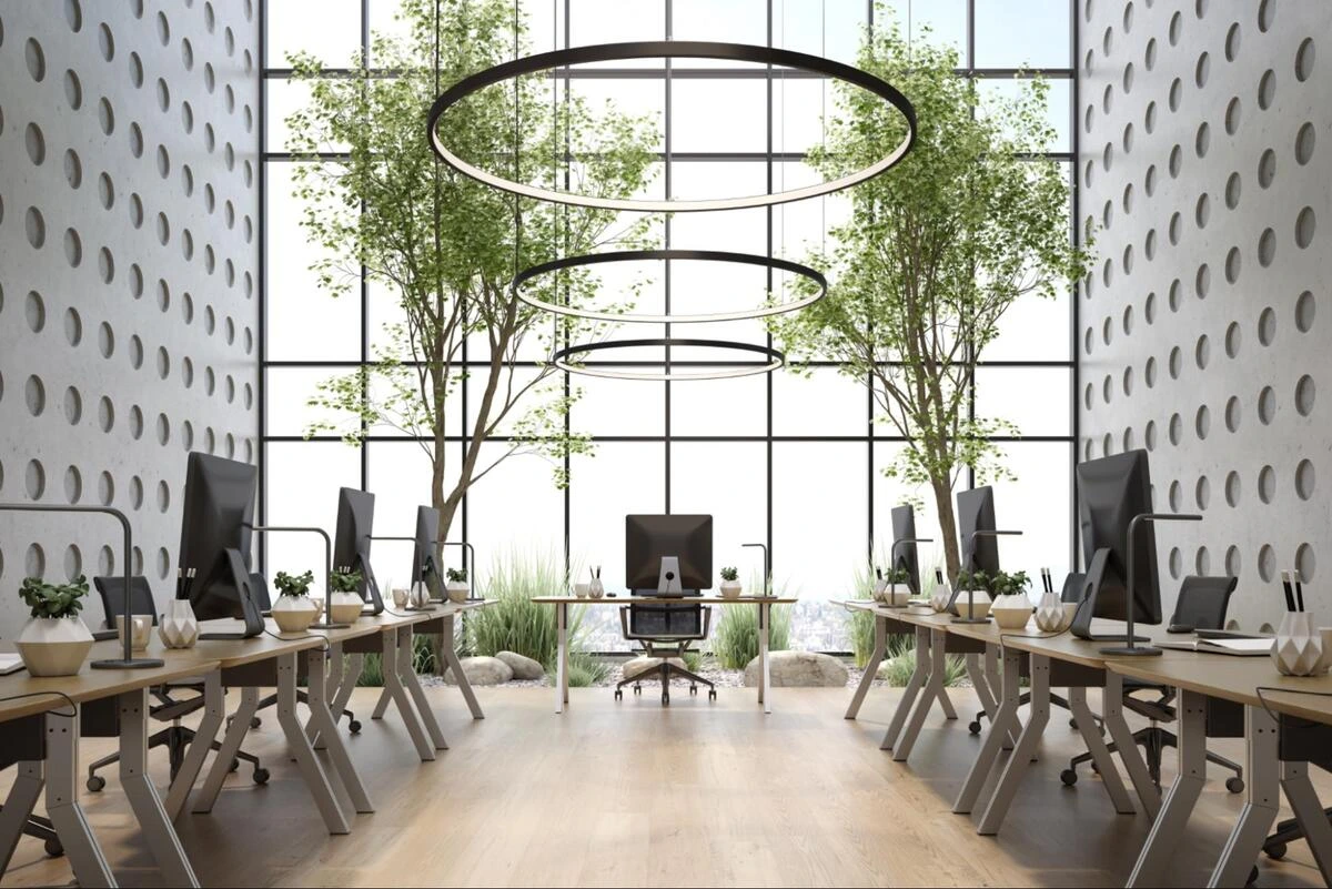 Modern Singapore office with tall indoor trees, open desk layout, and natural light from floor-to-ceiling windows